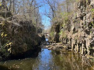Through waterway cut between two rock columns.