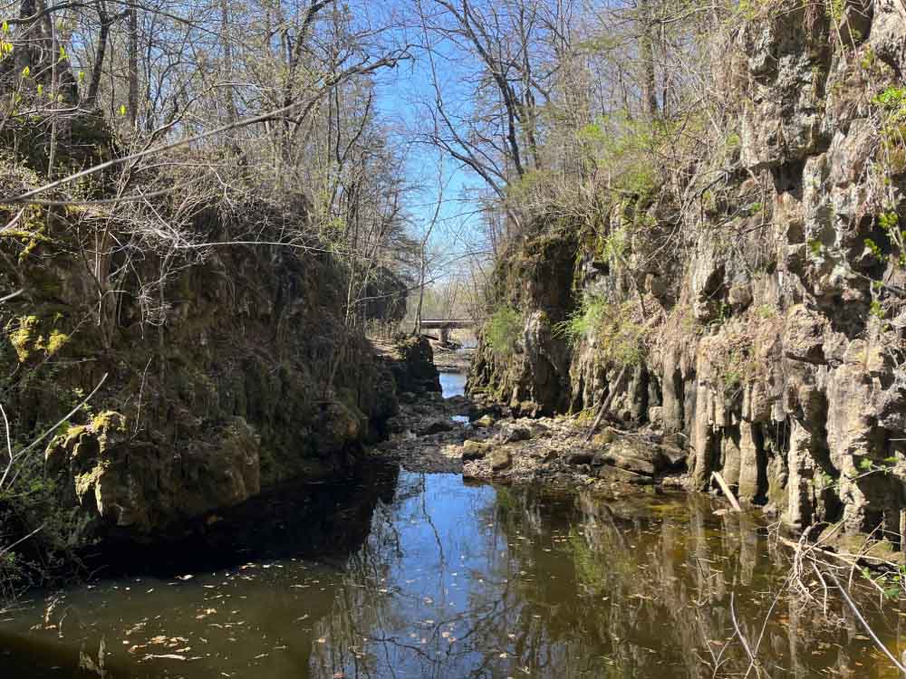 Through waterway cut between two rock columns.