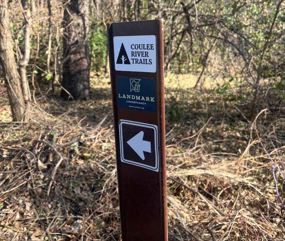 Directional sign naming the trail and Landmark Conservancy.